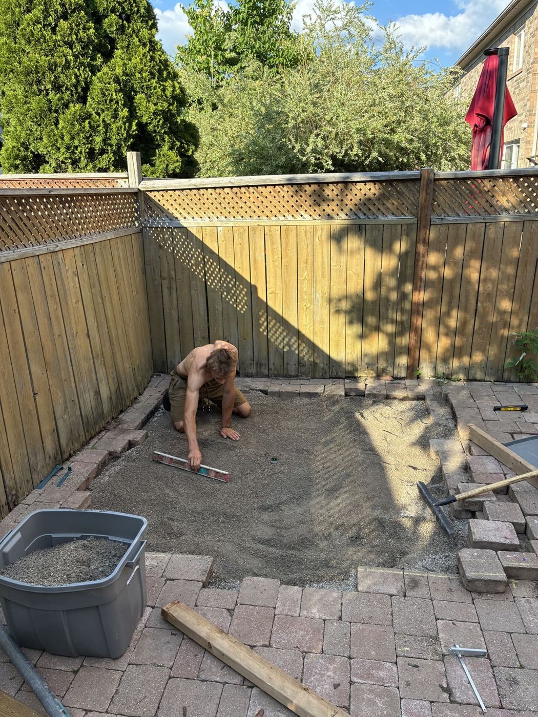 Crew screeding a fresh sand base for an interlock patio installation